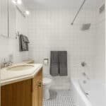 Clean bathroom with shower, bathtub, and wooden vanity.
