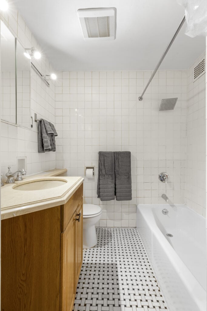 Clean bathroom with shower, bathtub, and wooden vanity.